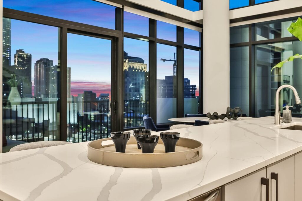 Kitchen area with countertops, island, single-sink open access to dining room, and exterior view of city